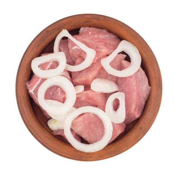 Carne cruda tagliata a pezzi con cipolle in un piatto marrone. Isola — Foto Stock