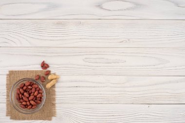 Eski ahşap masa üzerinde bir cam kase fıstık. 