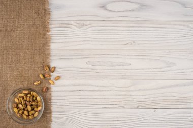 Eski Beyaz ahşap masa bir cam kase fıstık fındık. 