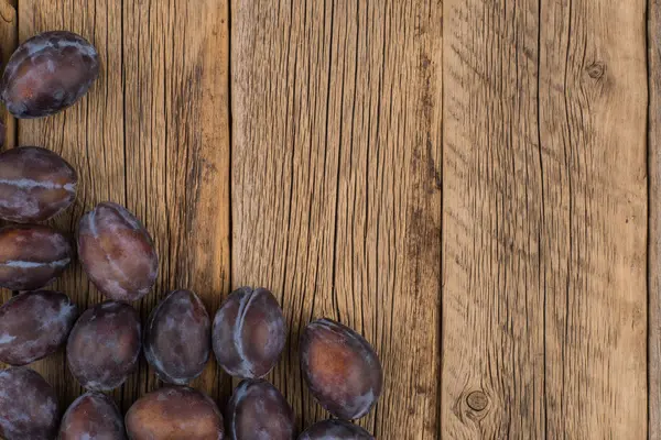 Ameixas frescas em uma mesa de madeira escura . — Fotografia de Stock