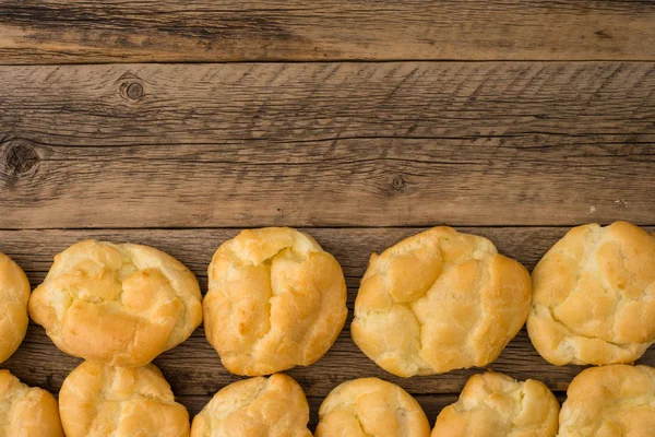 Eclairs on an old wooden table. — Stock Photo, Image