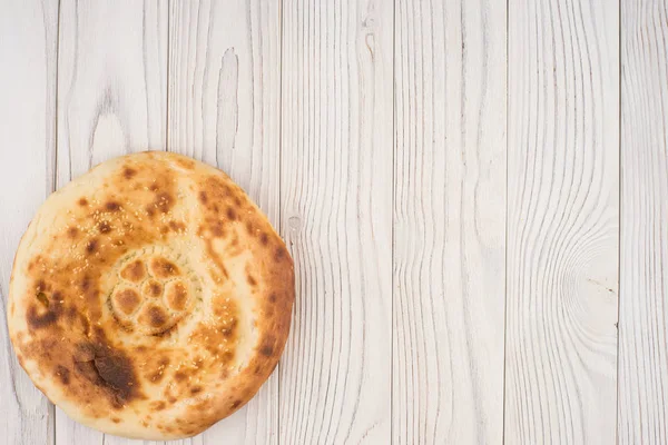 Pain ouzbek sur une vieille table en bois blanc . — Photo