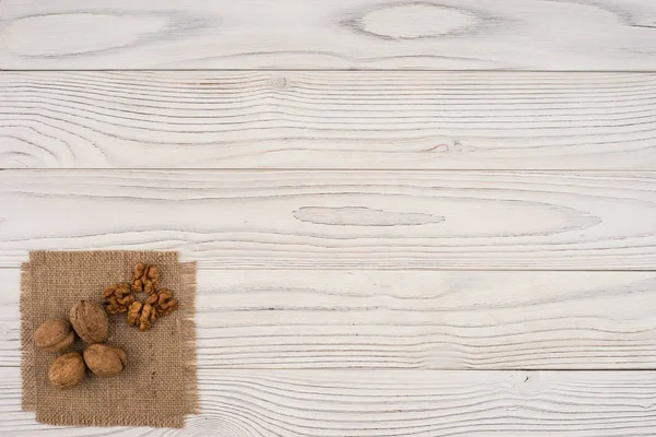 Nozes na velha mesa de madeira branca . — Fotografia de Stock