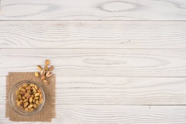 Eski Beyaz ahşap masa bir cam kase fıstık fındık. 