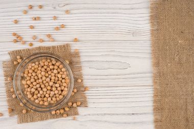 Eski ahşap masa üzerinde bir cam kapta nohut. 