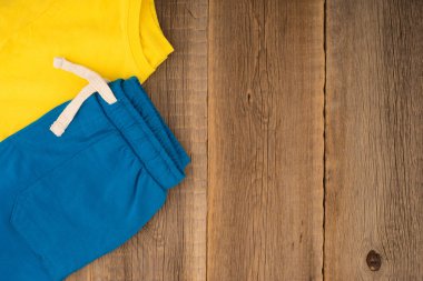 Eski ahşap masa üzerinde çocuk giyim spor. 