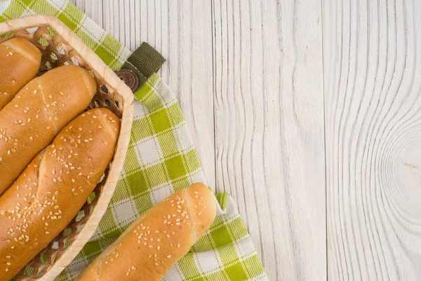 Buns in a wicker basket on old wooden table. — Stock Photo, Image