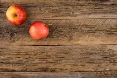 Eski ahşap masa üzerinde kırmızı elmalar. 