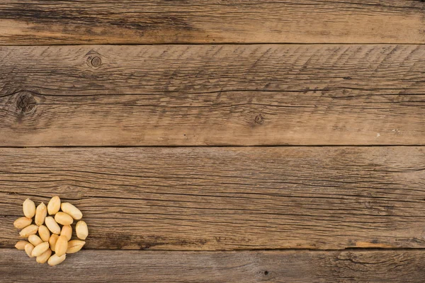 Peeled peanuts on an old wooden table. — Stock Photo, Image