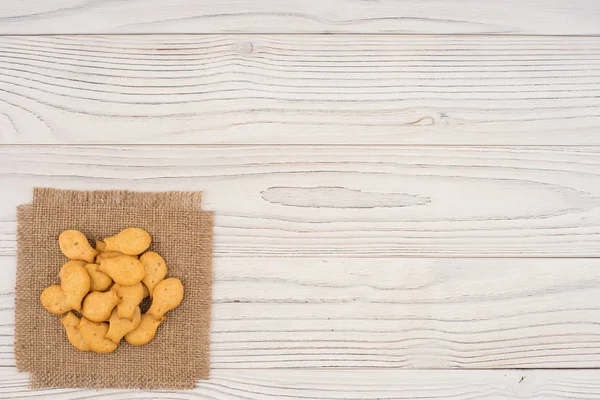 Cracker goldfish em pano de saco e mesa de madeira . — Fotografia de Stock