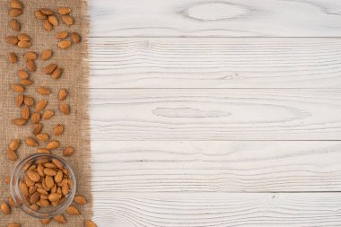 Badem bir cam kase ve eski Beyaz ahşap tablo. 