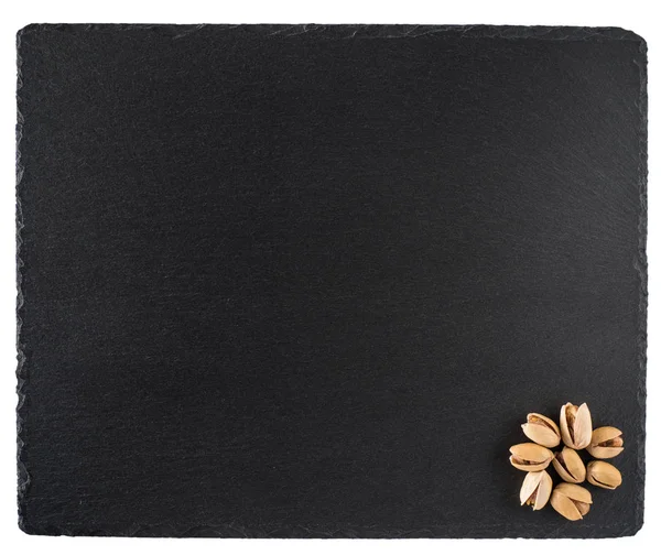 Pistachio nuts on a black slate board. Isolated on white backgro — Stock Photo, Image