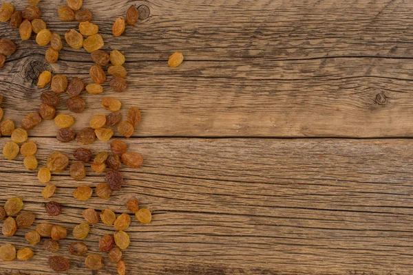 Eski ahşap masa üzerinde kuru üzüm. 