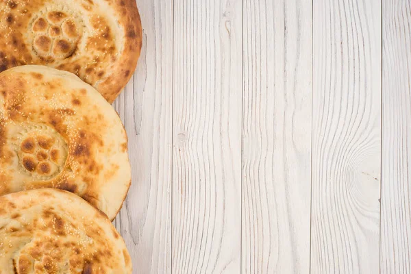 Uzbek bread on old white wooden table. — Stock Photo, Image
