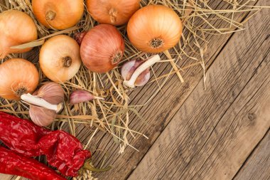 Soğan, sarımsak ve biber eski ahşap tablo. 