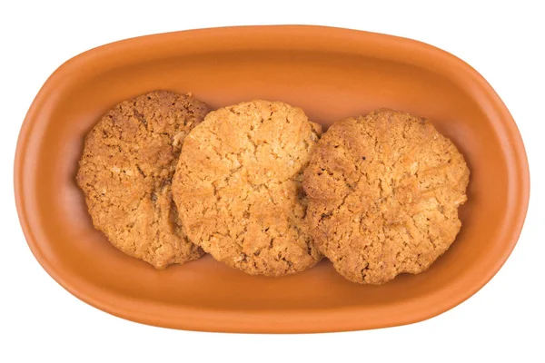 Oatmeal cookies in a brown plate. Isolated on white background. — Stock Photo, Image