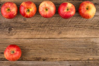 Eski ahşap masa üzerinde kırmızı elmalar. 