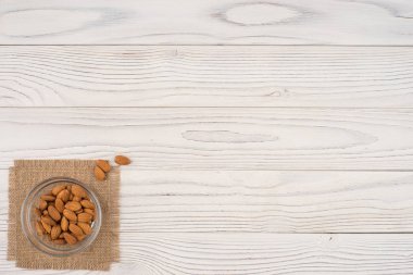 Badem bir cam kase ve eski Beyaz ahşap tablo. 