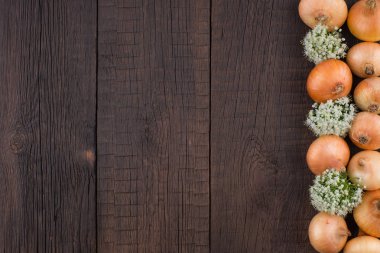 Eski ahşap bir masada soğanlar. 