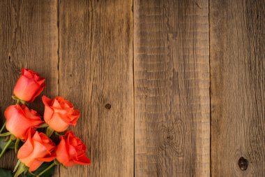 Eski bir ahşap masa üzerinde kırmızı gül.