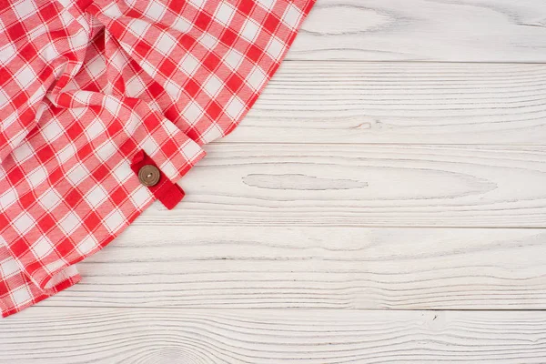 Mantel doblado rojo sobre mesa de madera blanqueada . — Foto de Stock
