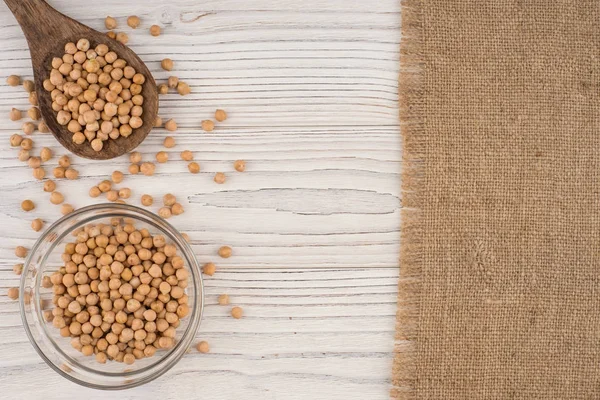 Eski ahşap masa üzerinde bir tahta kaşık nohut. 