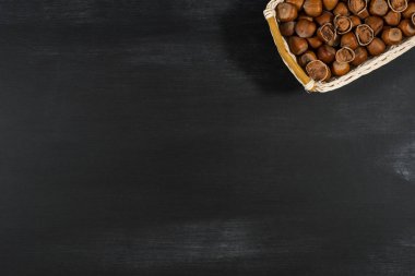 Bir kara tahta üzerinde bir sepet içinde fındık. 