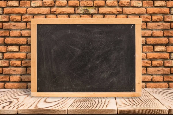 Blank blackboard on diagonal wooden table at red brick wall,Temp — Stock Photo, Image