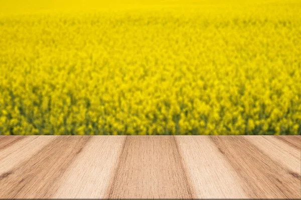Pranchas de madeira vazias com fundo borrado florescendo estupro amarelo — Fotografia de Stock