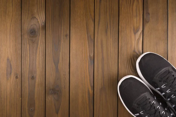 Чорні кросівки на дерев'яному фоні . — стокове фото