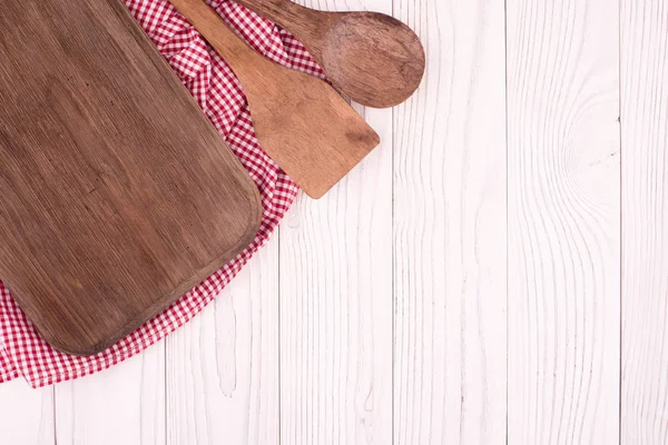 Tábua de corte e uma colher em um guardanapo de cozinha na velha mesa de madeira — Fotografia de Stock