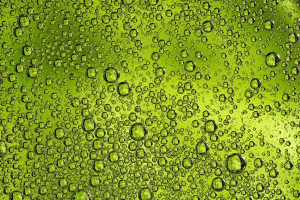 Абстрактний зелений фон з масляними колами. Бульбашки води крупним планом  . — стокове фото