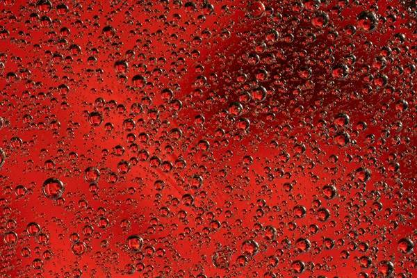 Abstracte rode achtergrond met oliekringen. Bubbels van water close-up . — Stockfoto
