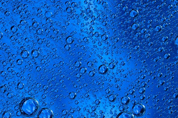 Μεγάλες όμορφες φυσαλίδες οξυγόνου κάτω από το νερό σε ένα μπλε μακροεντολή φόντο. — Φωτογραφία Αρχείου