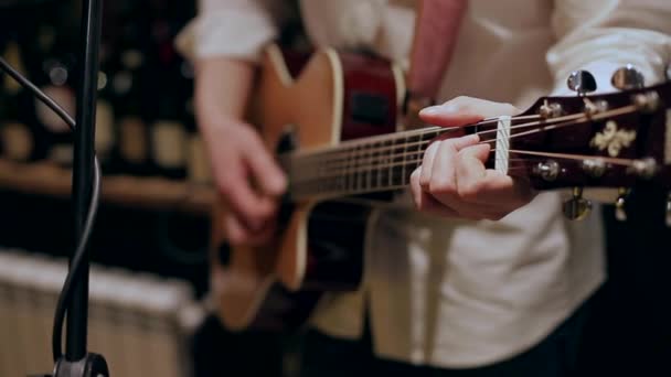 Een man speelt op gitaar en wisselt van akkoorden — Stockvideo