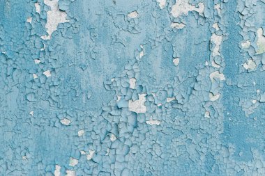 Terk edilmiş evdeki eski boya tabakalarıyla çatlamış bir duvar.