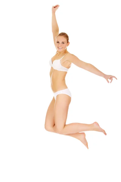 Happy young woman in white underwear jumping — Stock Photo, Image