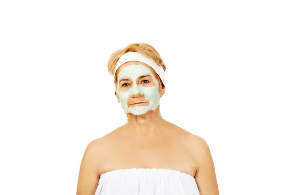 Relaxed elderly woman in facial mask — Stock Photo, Image