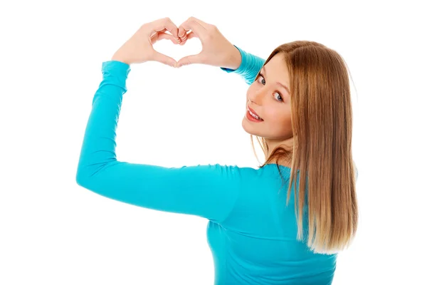 Smiling teenage woman making heart shape — Stock Photo, Image
