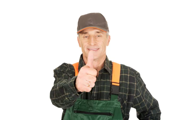 Mature gardener in uniform with thumbs up — Stock Photo, Image