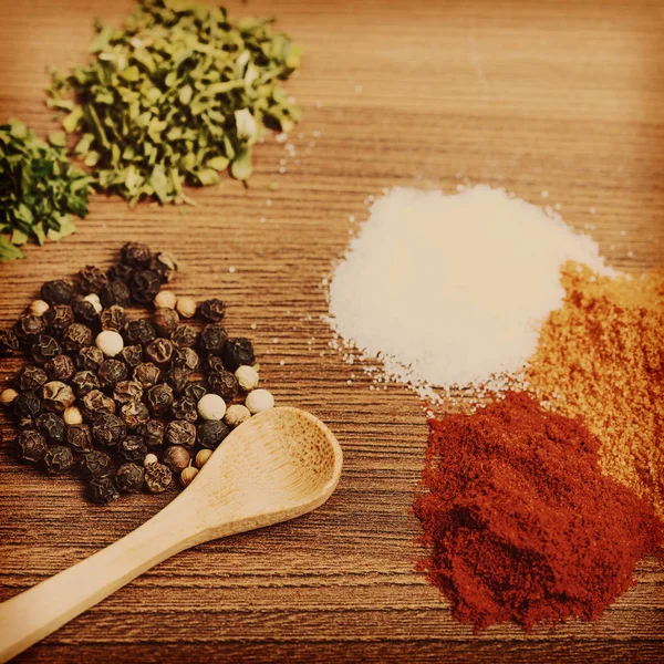 Heaps of spices with wooden spoon — Stock Photo, Image