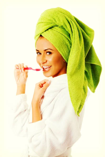 Woman in bathrobe brushing teeth — Stock Photo, Image