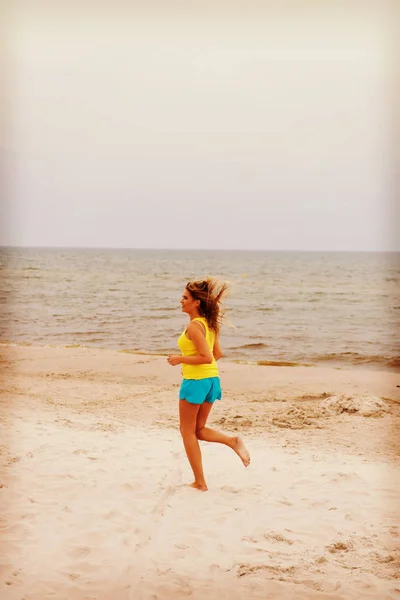 Giovane donna che corre sulla spiaggia — Foto Stock