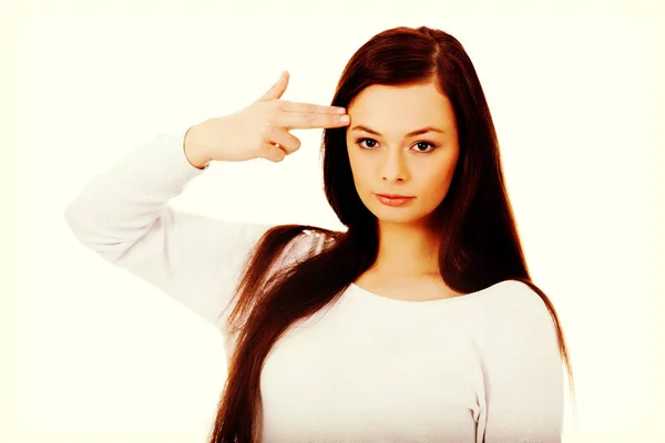 Young woman shoots herself in the head with finger gun gesture — Stock Photo, Image