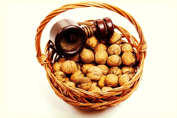 Walnuts in a willow basket with nutcracker — Stock Photo, Image