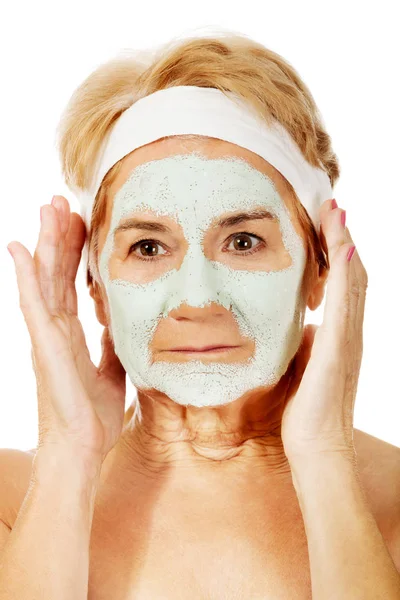 Relaxed elderly woman in facial mask — Stock Photo, Image