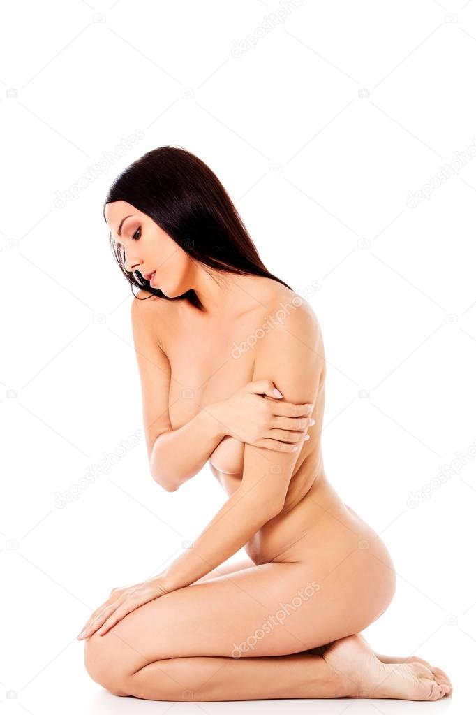 Nude woman kneeling on the floor
