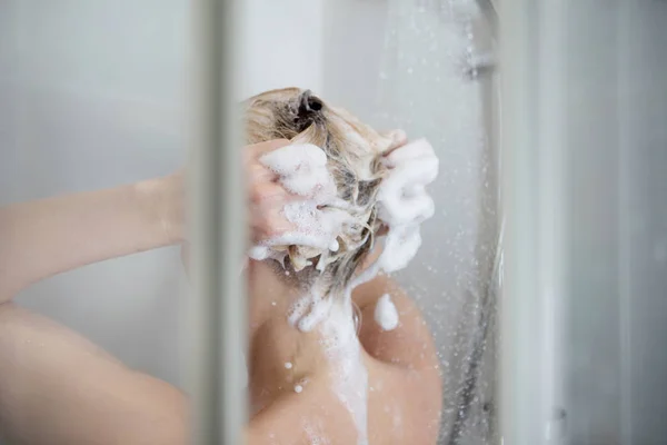 Krásná nahá žena myje vlasy při osprchování. — Stock fotografie