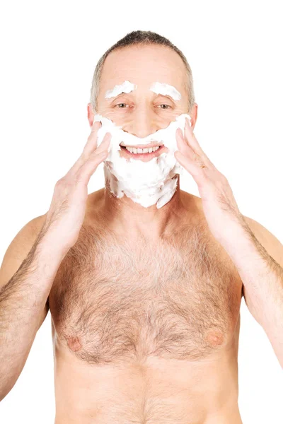 Человек, применяющий пену для бритья — стоковое фото