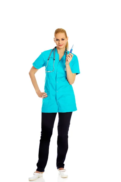Médica sorridente com estetoscópio segurando termômetro — Fotografia de Stock